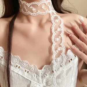 Macro detail of a French style white lace skinny ribbon necklace worn on the neck.