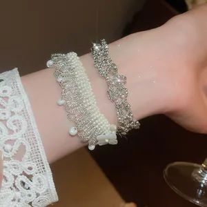 Macro view of elegant French-style pearl fringe and sparkling silver-tone beaded bracelet set