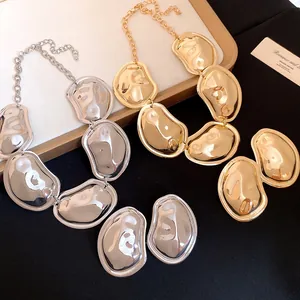 Close-up of gold and silver metallic oval wrinkled necklaces and earrings jewelry set
