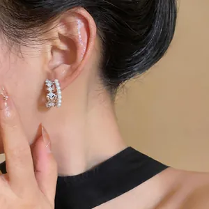 Detailaufnahme von eleganten zweireihigen Creolen mit glänzenden Kristallen und Perlen