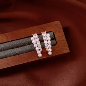 Elegantes pendientes de oro con perlas blancas redondas y brillantes acentos de circón