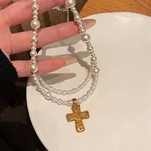 Elegant double-layered pearl necklace with textured gold cross pendant for women