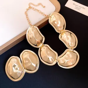 Detail view of chunky gold metallic crumpled oval necklace and earring set