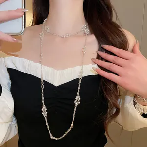 Detail of an elegant French style pearl beaded long necklace worn on a model's neck