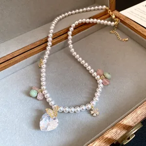 Macro view of pearl necklace details including zircon heart and butterfly charms