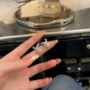 Vue détaillée d'élégantes boucles d'oreilles nœud en argent avec centre en zircon