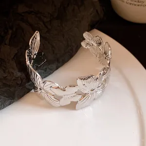 Macro view of the intricate pleated butterfly design on the silver open cuff bangle