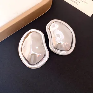 Detail view of silver pleated metallic earrings with an irregular oval shape.