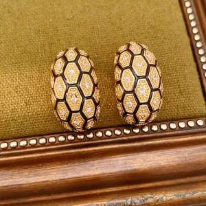 Détail macro exquis de boucles d'oreilles en nid d'abeille plaquées or 18 carats avec zircon