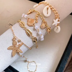 Bohemian gold bracelet set with sea shells, starfish, and pearls for a beach look.