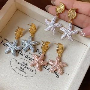 Vista detallada de pendientes de estrella de mar bañados en oro 18k en tres colores