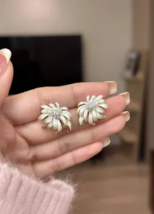 Detailed view of pale yellow chamomile flower stud earrings featuring a sparkling crystal center