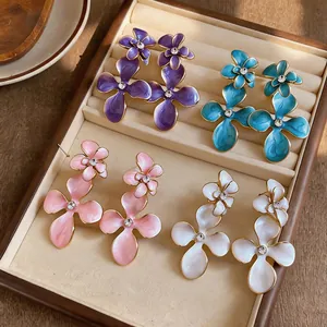 Detailed view of four pairs of vintage enamel flower earrings with rhinestone centers.