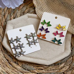 Vista detallada de pendientes de mariposa y estrella de mar en tarjetas de exhibición