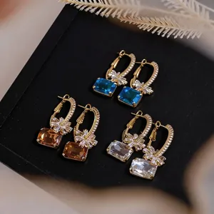 Elegante Creolen mit floralen Zirkonia-Steinen in Blau, Bernstein und klaren Farben.