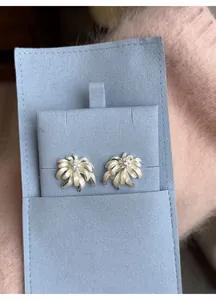 Elegant gold chamomile flower stud earrings with matte petals on blue jewelry card