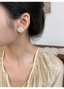 Close-up showing the elegant chamomile flower stud earring worn on the ear