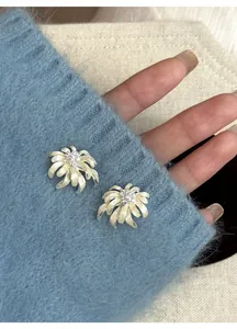 Close-up of elegant cream chamomile flower stud earrings with sparkling crystal center