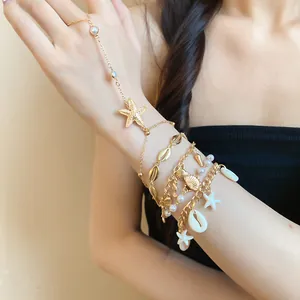 Bohemian style gold shell and starfish hand chain bracelet set with pearl accents