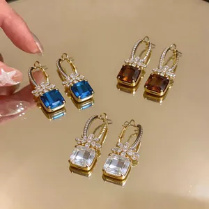 Detaillierte Nahaufnahme von luxuriösen geometrischen Zirkon-Ohrringen in drei eleganten Farben