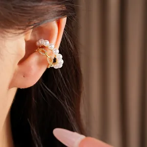 Primer plano detallado de un elegante ear cuff de doble capa con perlas y circonitas.