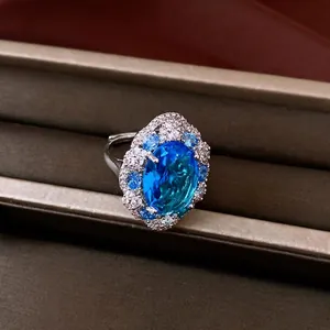 Luxury silver-tone ring featuring a large oval blue zircon surrounded by small crystals
