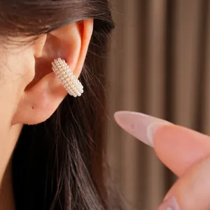 Primer plano del elegante pendiente de cartílago de perlas de varias filas en la oreja