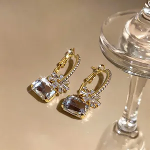 Nahaufnahme eleganter goldener Creolen mit funkelnden floralen Zirkonia
