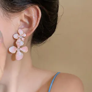 Detailed close-up of elegant pink oil-drop flower stud earrings with rhinestones
