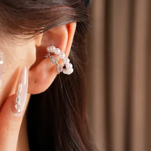 Detalle de un elegante pendiente de clip de doble capa con perlas y circonitas brillantes