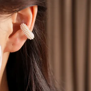 Detalle de un elegante clip de oreja de doble capa de perlas para orejas sin agujeros