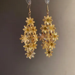 Eleganti orecchini pendenti a nappa con fiori stratificati in tonalità oro lucido