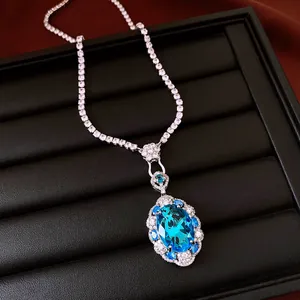 Close-up of elegant oval blue zircon pendant on a sparkling tennis chain necklace