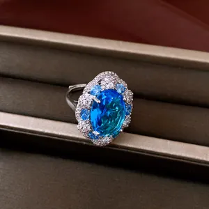Macro view of an elegant silver ring featuring a large oval blue zircon with halo stones