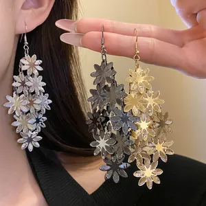 Vista dettagliata di eleganti orecchini pendenti a nappa con fiori di metallo argento oro nero.
