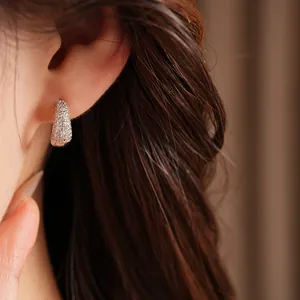 Close-up of elegant 14K gold plated hoop earrings paved with white cubic zirconia