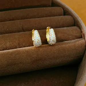 Close-up of 14K gold plated hoop earrings with micro-pave zircons in a brown velvet box.