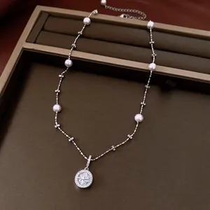 Close-up of a vintage zircon star pendant necklace with delicate small white pearls on the chain