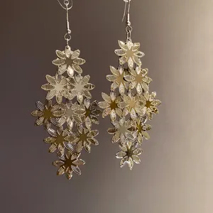 Vista dettagliata di eleganti orecchini a goccia nappa con fiori in metallo oro da donna
