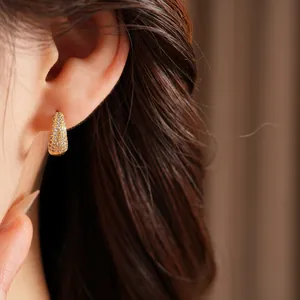 Close-up of 14K gold plated huggie hoop earrings with sparkling pavé zircon stones