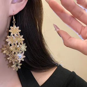Primo piano dettagliato di eleganti orecchini pendenti a fiori dorati a strati
