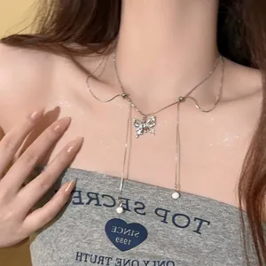 Close-up of double-layer butterfly necklace with tassels and pearls on model neck