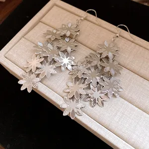 Vista dettagliata di orecchini a nappa con fiori metallici con finitura argento lucido.