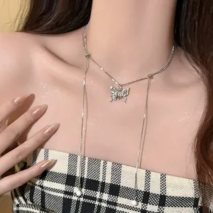Detailed shot of a stylish silver butterfly necklace with pearl tassels worn by a model
