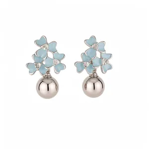 Boucles d'oreilles fleurs bleu clair avec boules métalliques argentées, look d'été doux