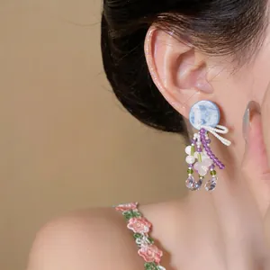 Gros plan détaillé de boucles d'oreilles en perles faites main avec clou en marbre bleu