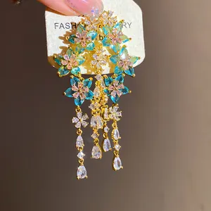 Detail view of exquisite floral zircon earrings with blue petals and teardrop tassels.