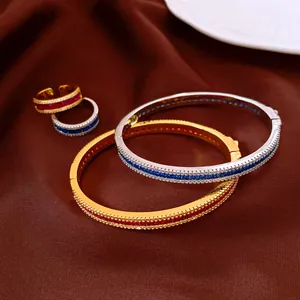 Detail of vintage-style zircon bangles and rings with red and blue gemstones