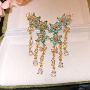 Elegant gold-plated zirconia flower earrings with blue and pink stones detail.