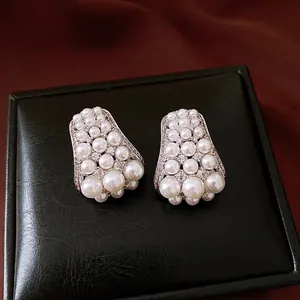 Orecchini vintage con perle e zirconi presentati su una lussuosa scatola di pelle nera.